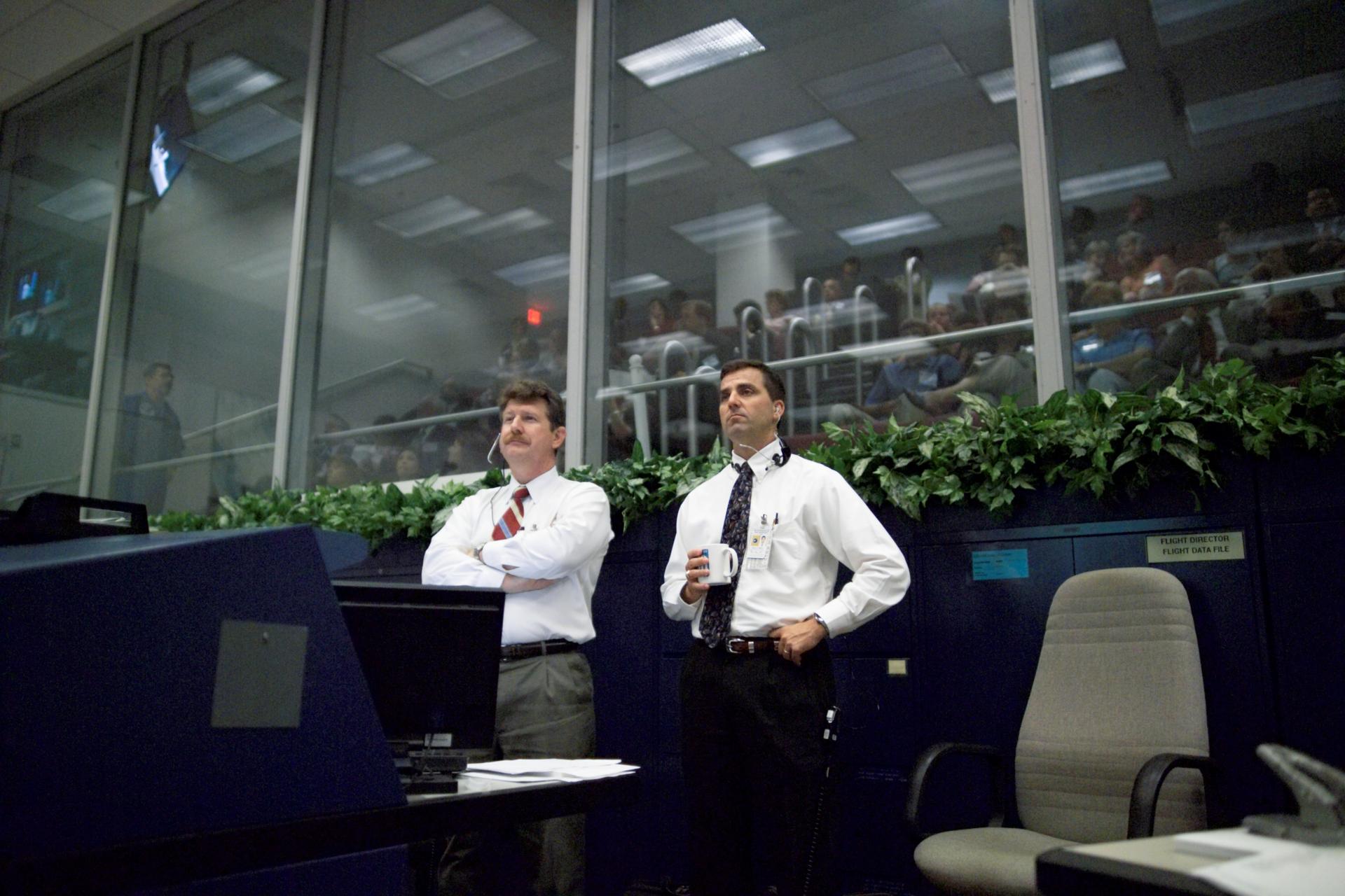 NASA-Flugleiter überwachen Bildschirme und Systeme beim STS-114-Einsatz im Mission Control Center – als Analogie für konzentriertes IT-Monitoring und On-Call-Betrieb